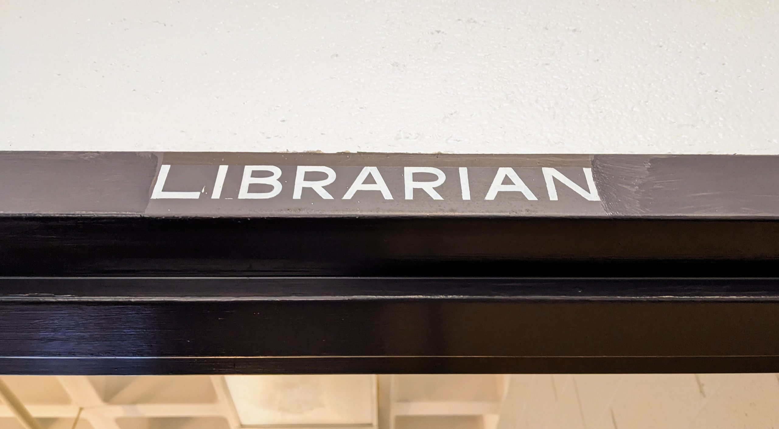 A hand-painted sign above a doorway that reads "Librarian."
