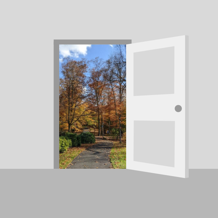 An open door leading from a colorless room to a brightly colored, tree-lined path.